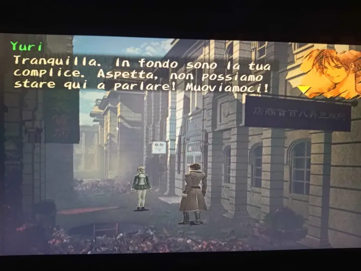 Screenshot di Shadow Hearts: Covenant con la traduzione italiana automatica: «Yuri: Tranquilla. In fondo sono la tua complice. Aspetta, non possiamo stare qui a parlare!…